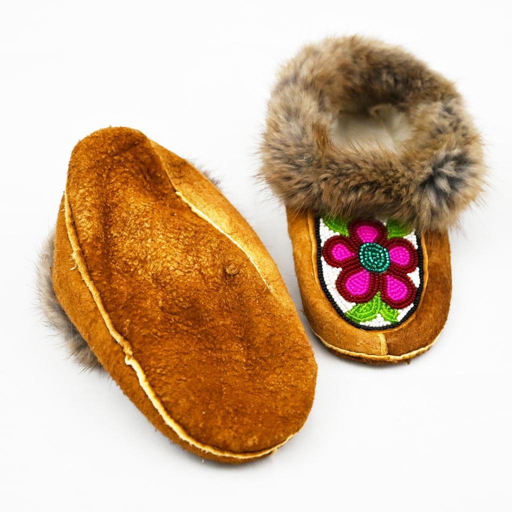 Beaded children's moccasins. Muskrat trim, home tan elk hide, beadwork and fleece. Beaded pink flowers and fur trim.