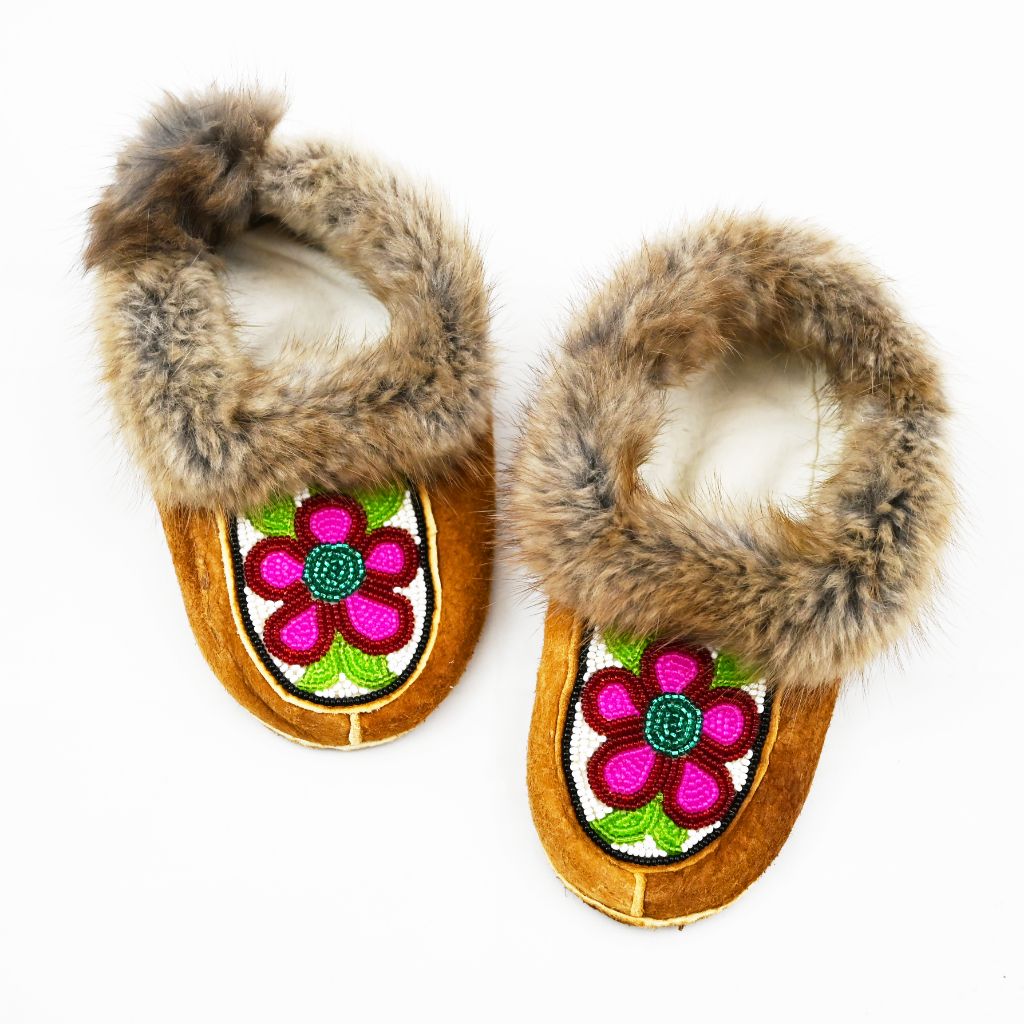 Beaded children's moccasins. Muskrat trim, home tan elk hide, beadwork and fleece. Beaded pink flowers and fur trim.