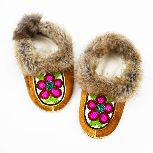 Beaded children's moccasins. Muskrat trim, home tan elk hide, beadwork and fleece. Beaded pink flowers and fur trim.