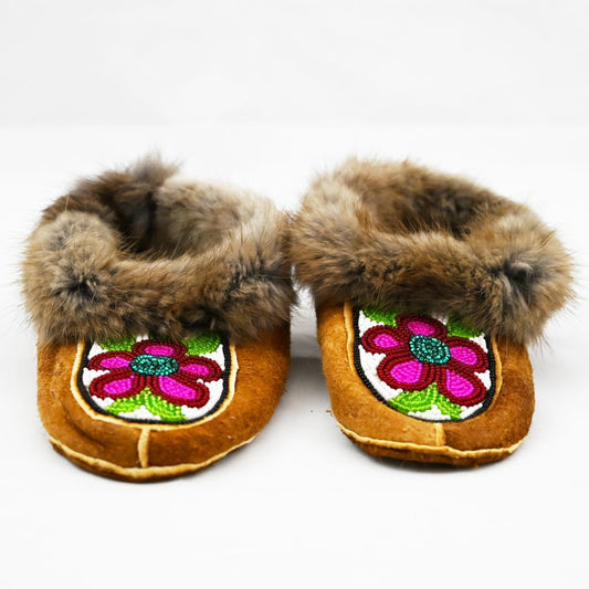 Beaded children's moccasins. Muskrat trim, home tan elk hide, beadwork and fleece. Beaded pink flowers and fur trim.